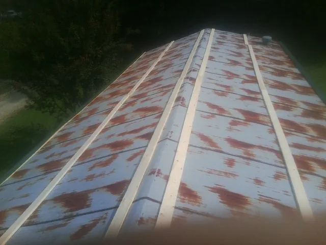 Rusted metal roof panels with new wood purlins before replacement — Storm Damage Roof Repair in College Station by Roofing Brothers