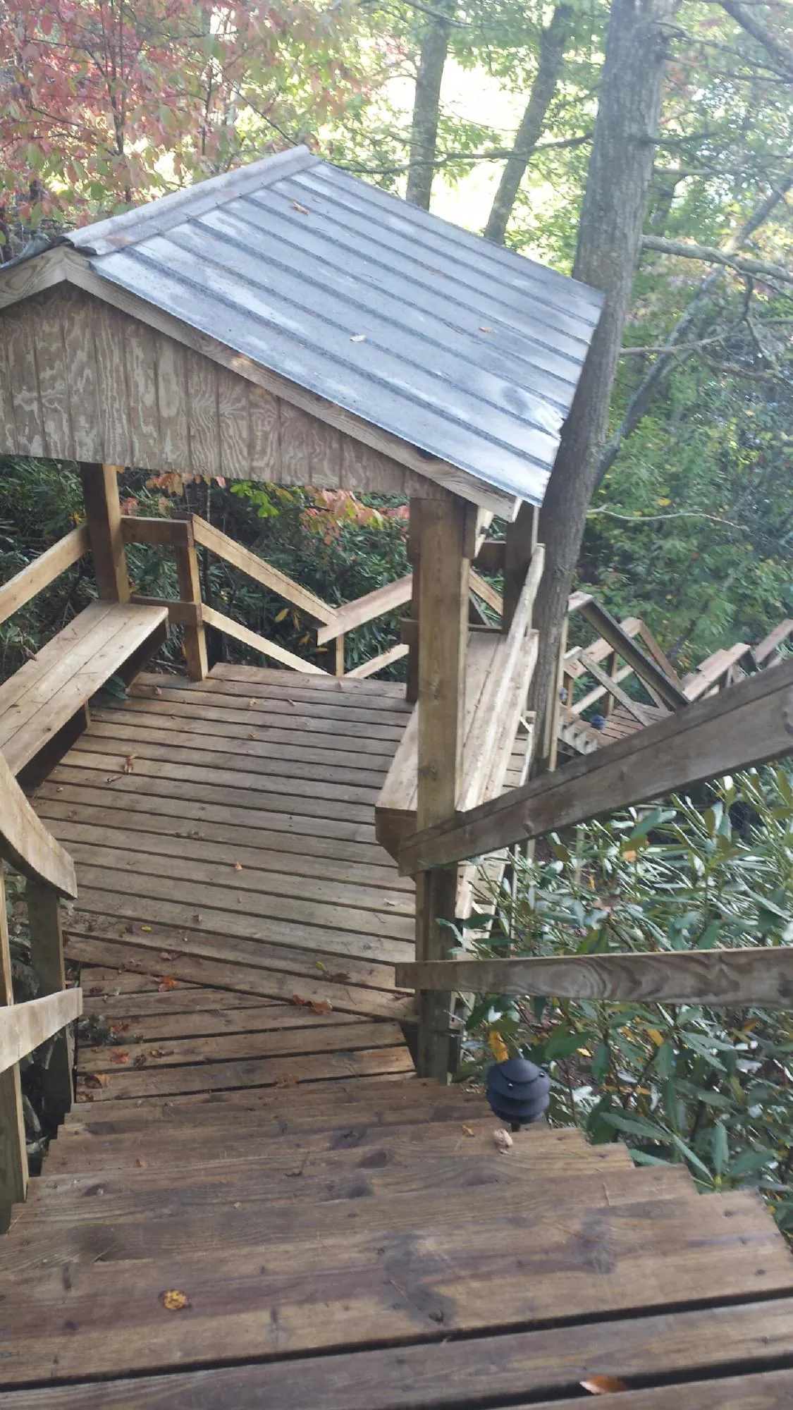 Metal roofed shelter over wooden steps on a wooded walkway — Skylight Repair & Installation work by our crew in College Station