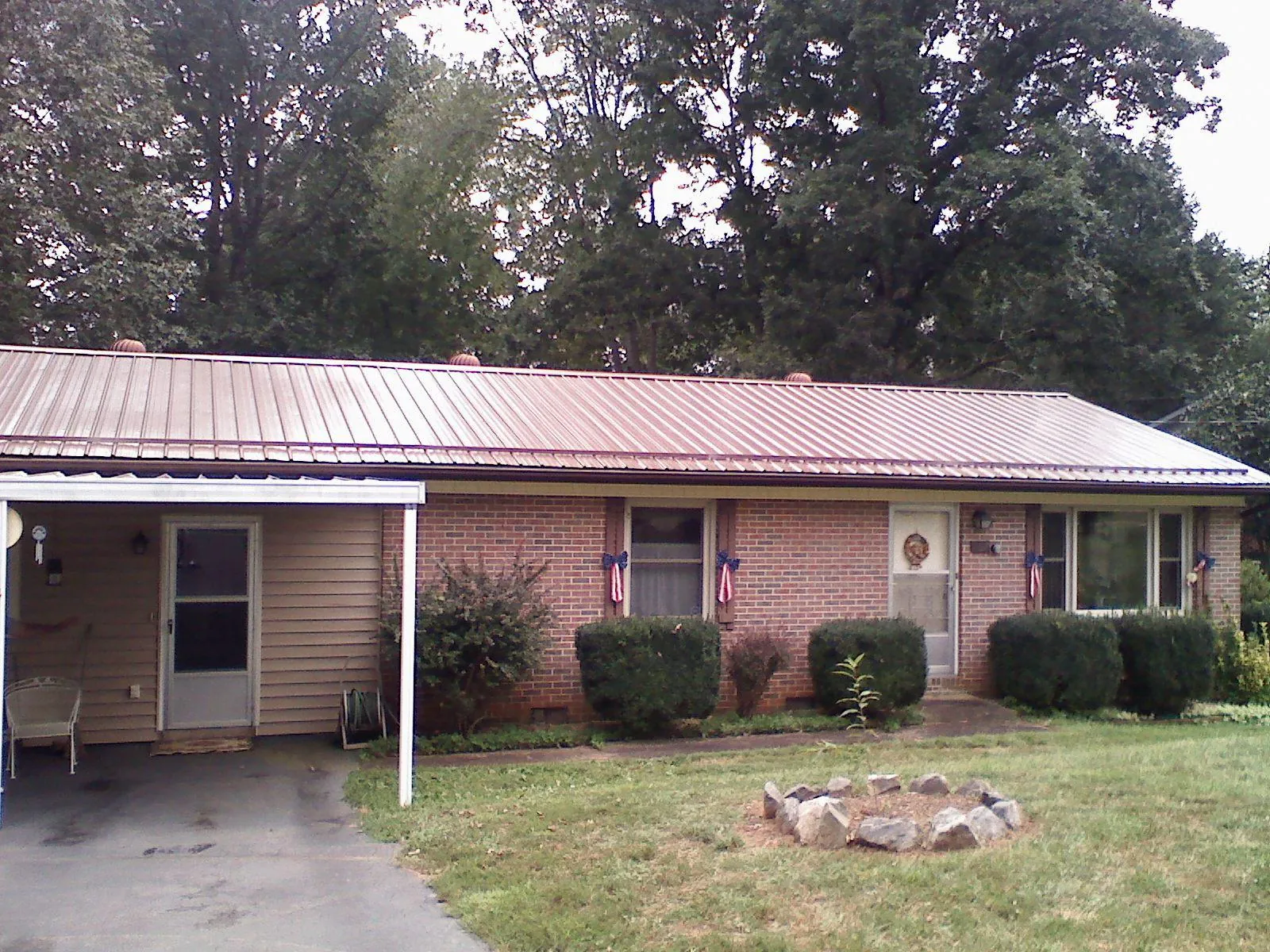Bronze metal roof and carport on a brick ranch home — Roof Repair work by our crew in College Station