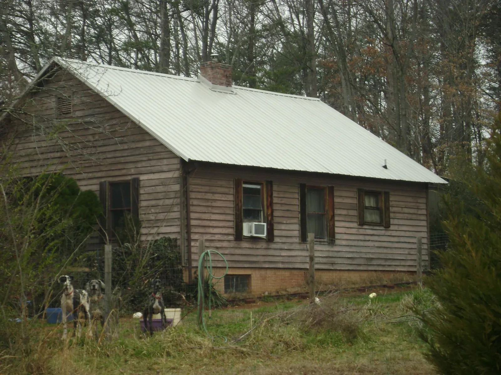White metal roof on an old wood sided farmhouse, from a Metal Roof Installation job in College Station